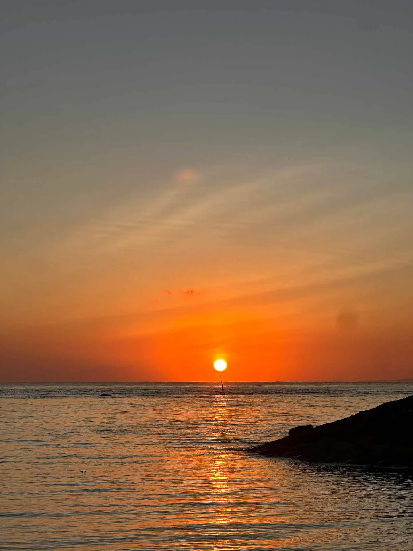 The sun rising over a calm sea.
